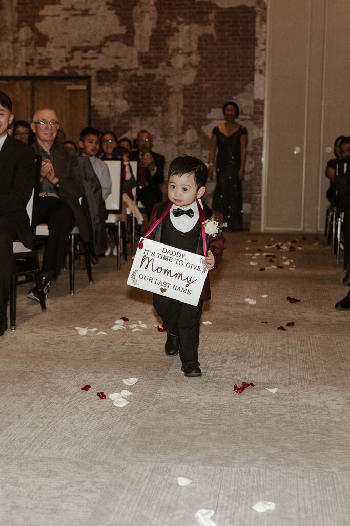 a boy ring bearer walking down the aisle for a winter wedding at the whitney peak hotel