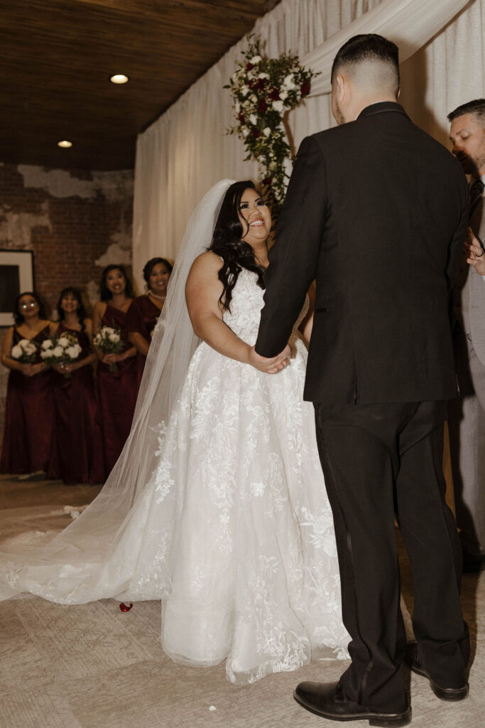 bride and groom holding hands and smiling during their ceremony at the whitney peak hotel