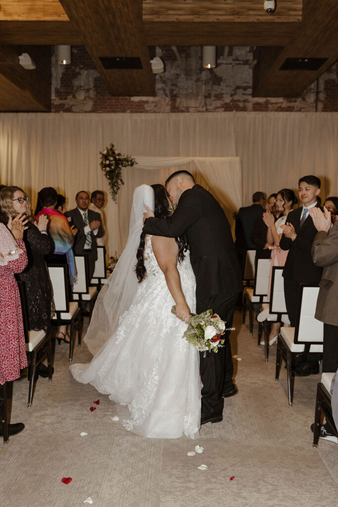 bride and groom kissing in the aisle at the whitney peak hotel