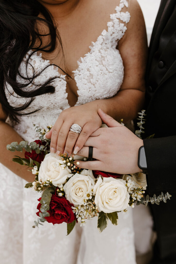 bride and groom showing rings with wedding bouquet underneath at the whitney peak hotel