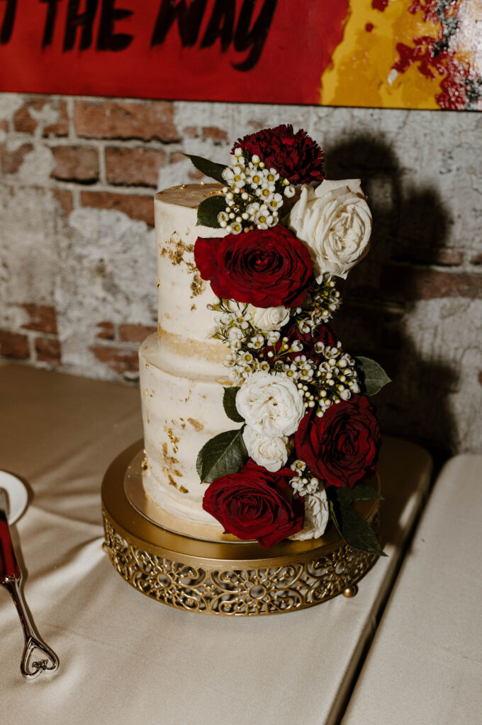red and white rose wedding cake with gold flakes for winter wedding at the whitney peak hotel