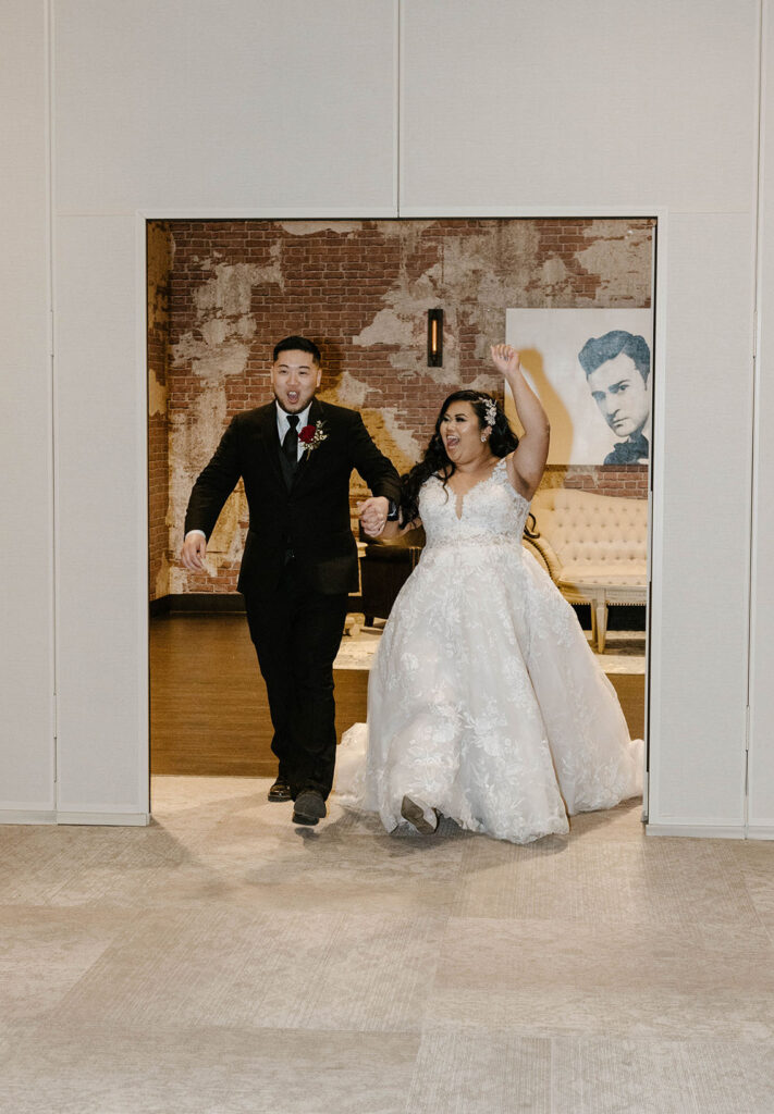 bride and groom cheering as they enter their wedding reception at the whitney peak hotel