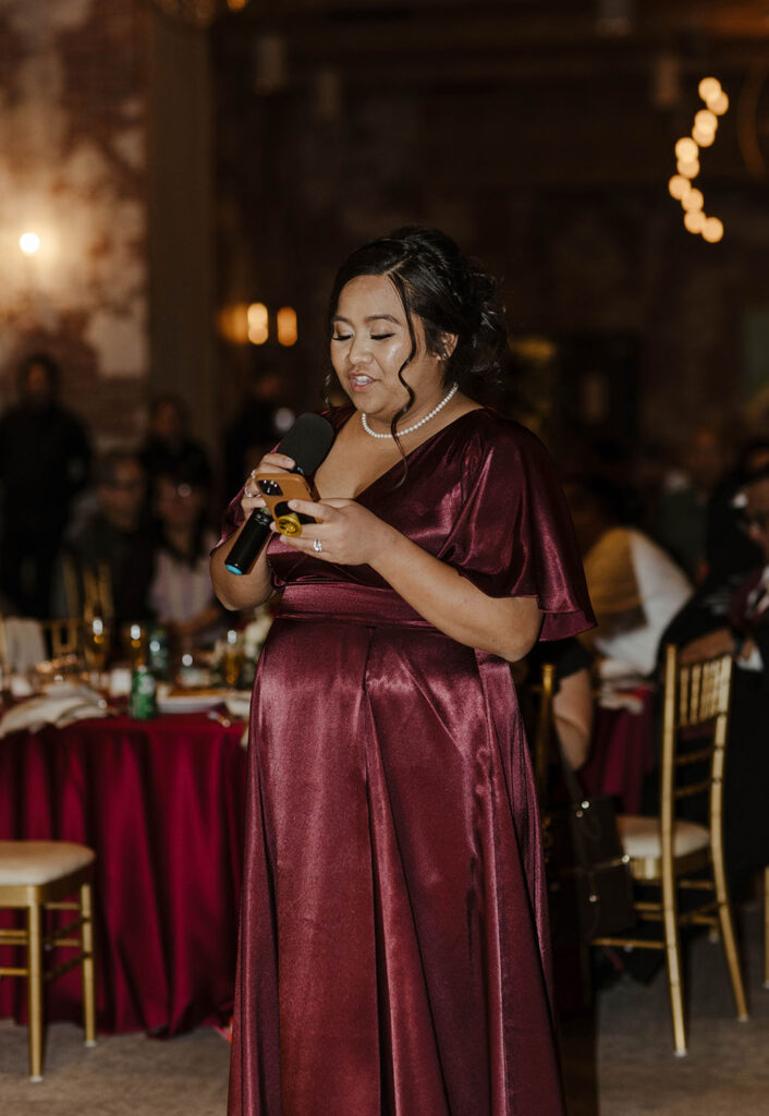 woman in maroon dress giving a speech at a winter wedding at the whitney peak hotel