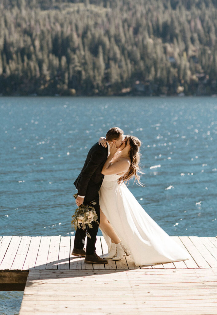 Elopement couple holding each other and kissing on dock at Donner lake