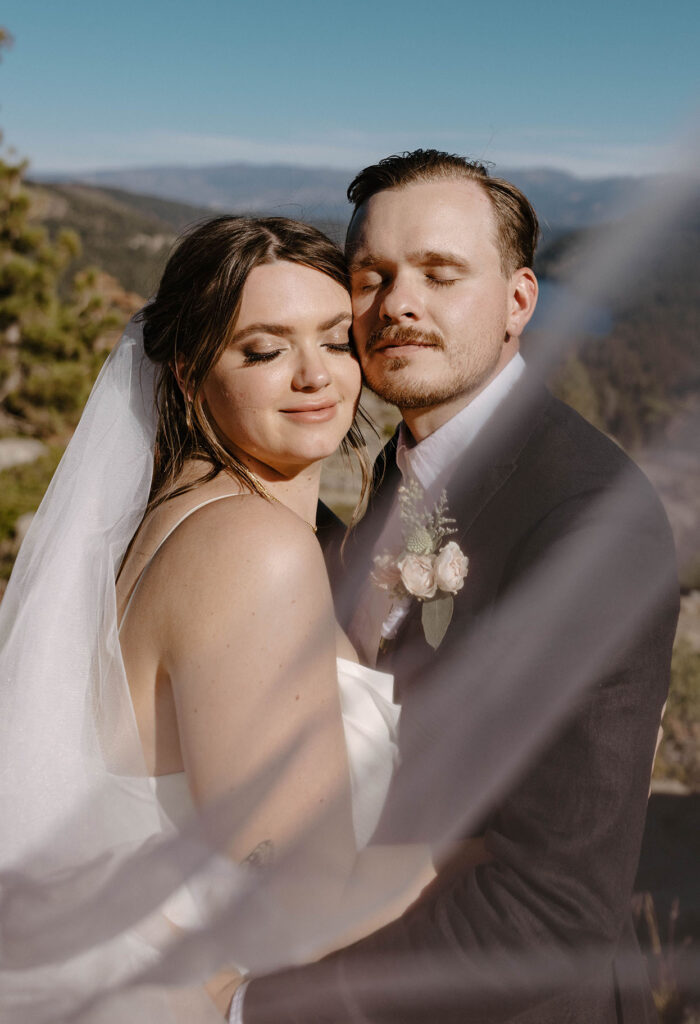Elopement couple smiling with eyes closed while looking at camera in Donner lake