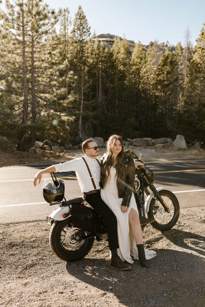 Elopement couple sitting on motorcycle together as they look into the distance at Donner lake