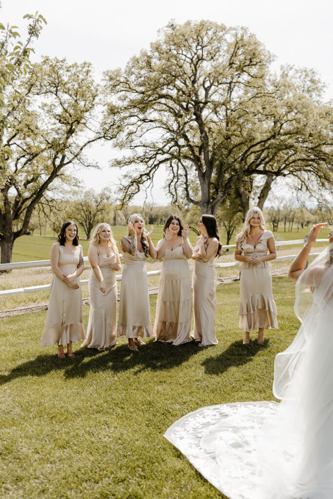 Bridesmaids emotional and reacting during first look with wedding bride outside at little bear creek ranch