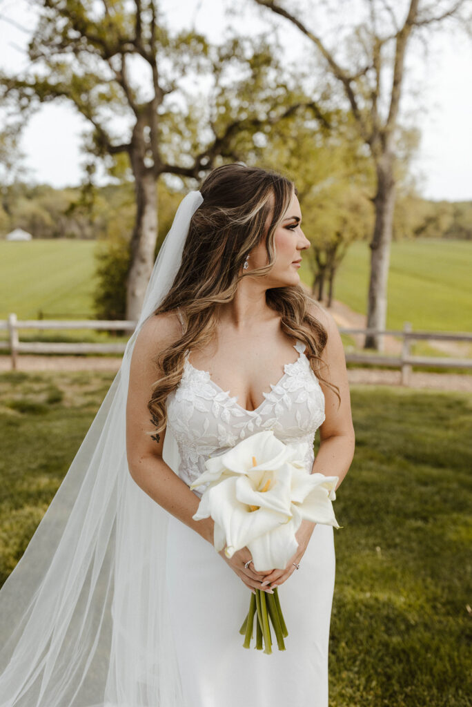 Wedding bride holding flower bouquet while looking off to the side at little bear creek ranch