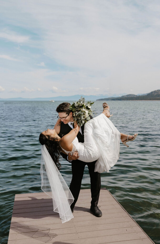Groom picking up and swinging elopement bride while on a pier in Lake Tahoe
