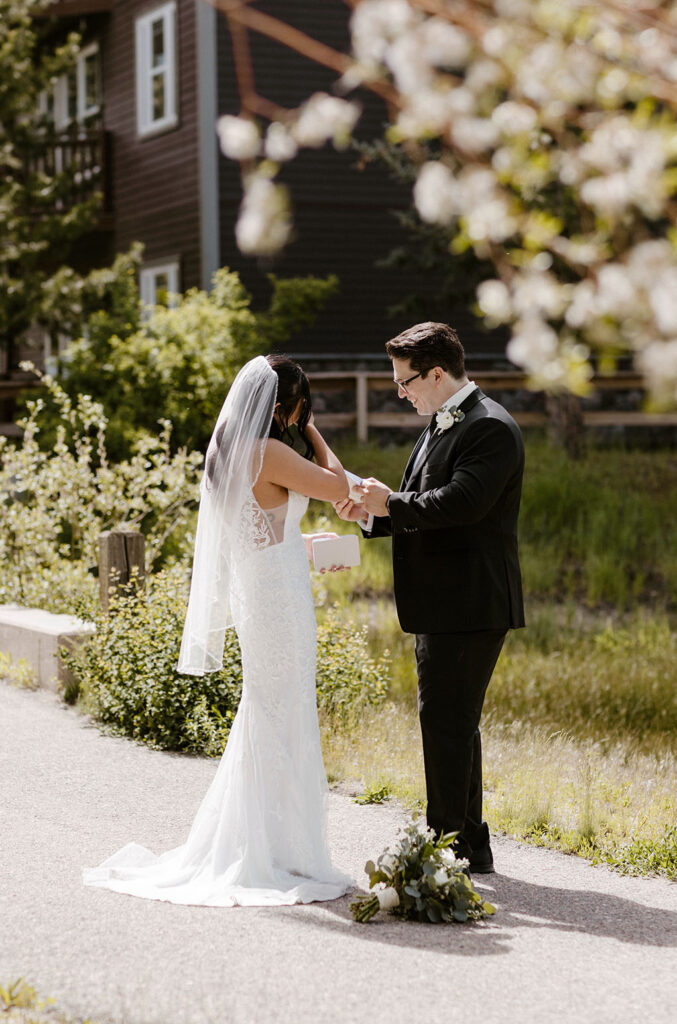 Elopement groom reading wedding vows to emotional bride while standing on walkway surrounded by greenery in Lake Tahoe