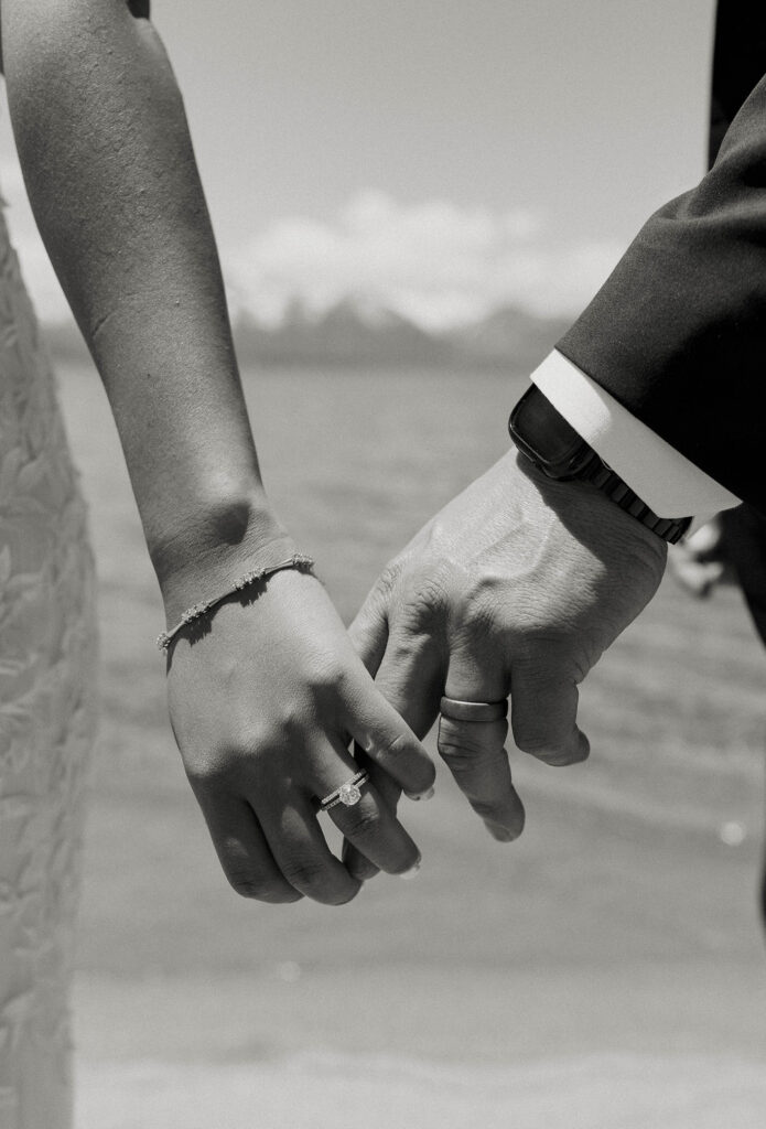 Close up of elopement couples hands holding each other with wedding rings on in Lake Tahoe
