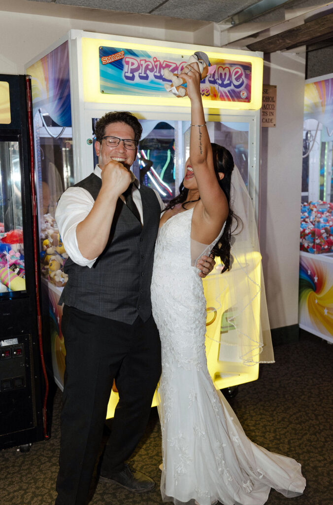 Elopement couple cheering together after winning arcade game inside casino in Lake Tahoe