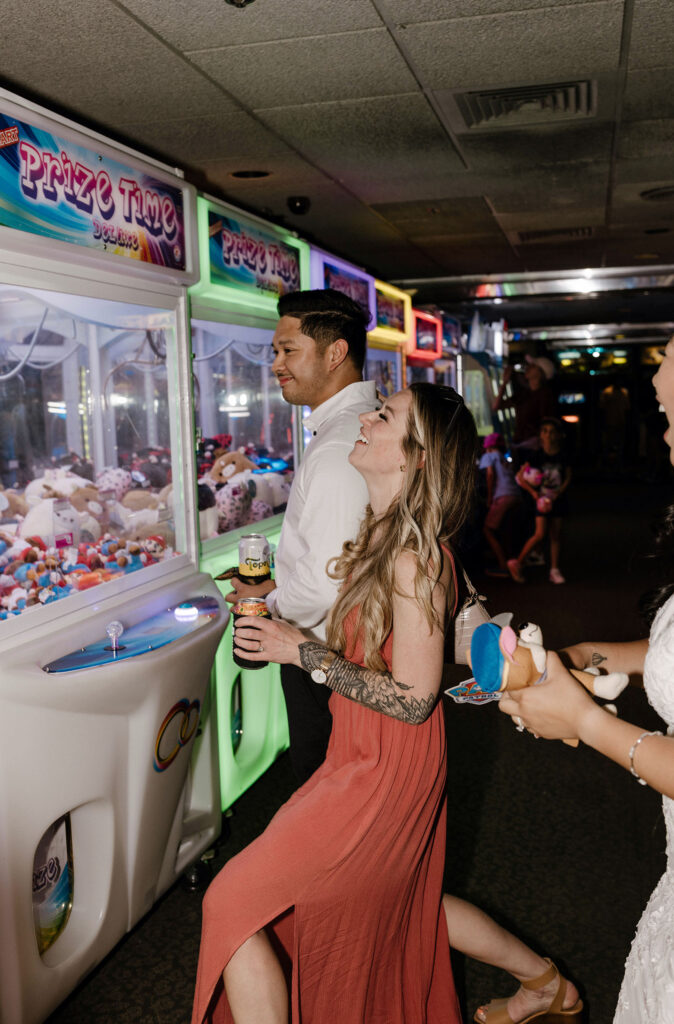 Elopement guests playing arcade games while laughing and drinking inside casino in Lake Tahoe