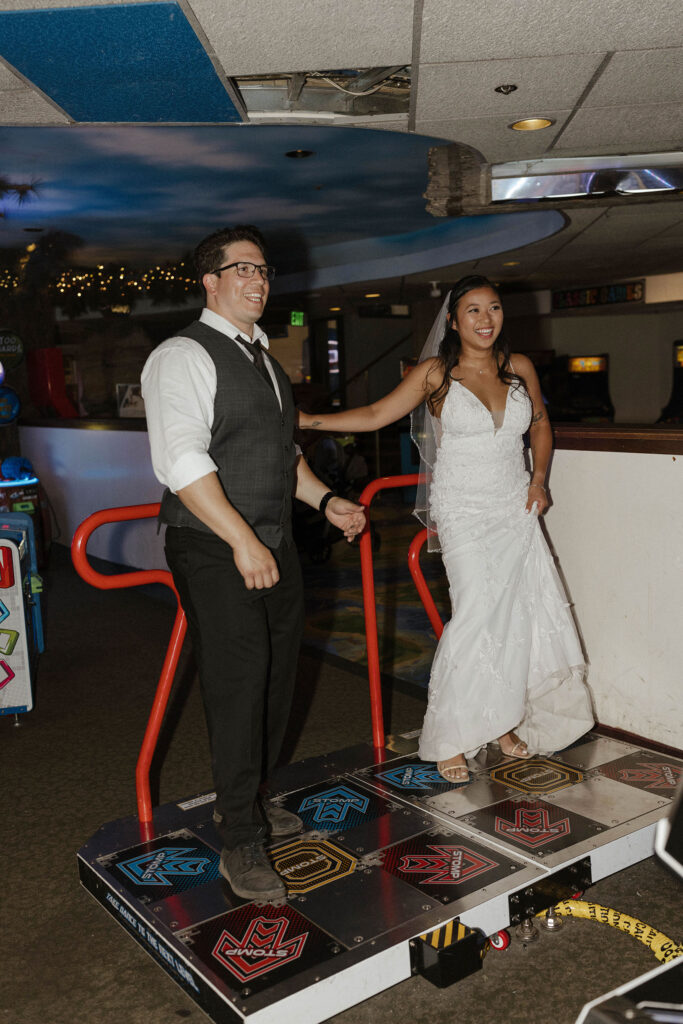 Elopement couple laughing while playing dancing arcade game together inside casino at Lake Tahoe