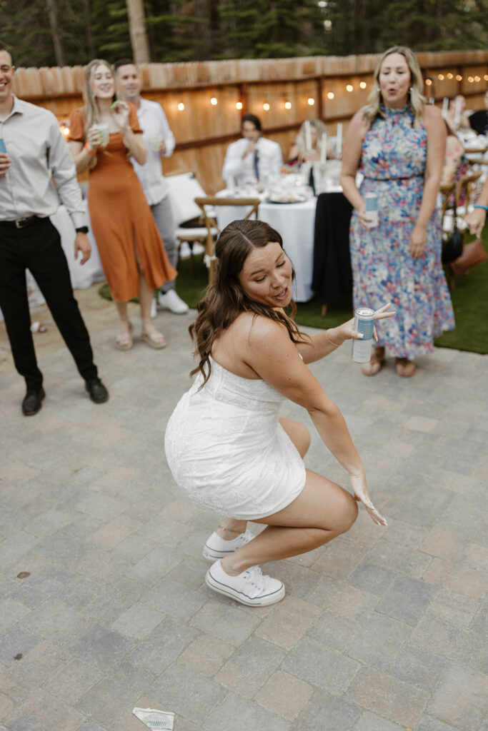 Wedding bride dancing while holding drink during reception in Lake Tahoe