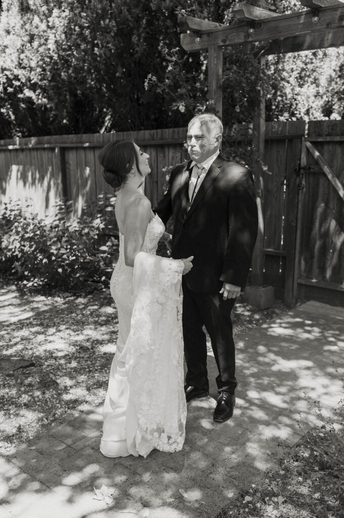 Bride's dad standing with eyes closed during first look as bride walks up smiling at French Oak Ranch