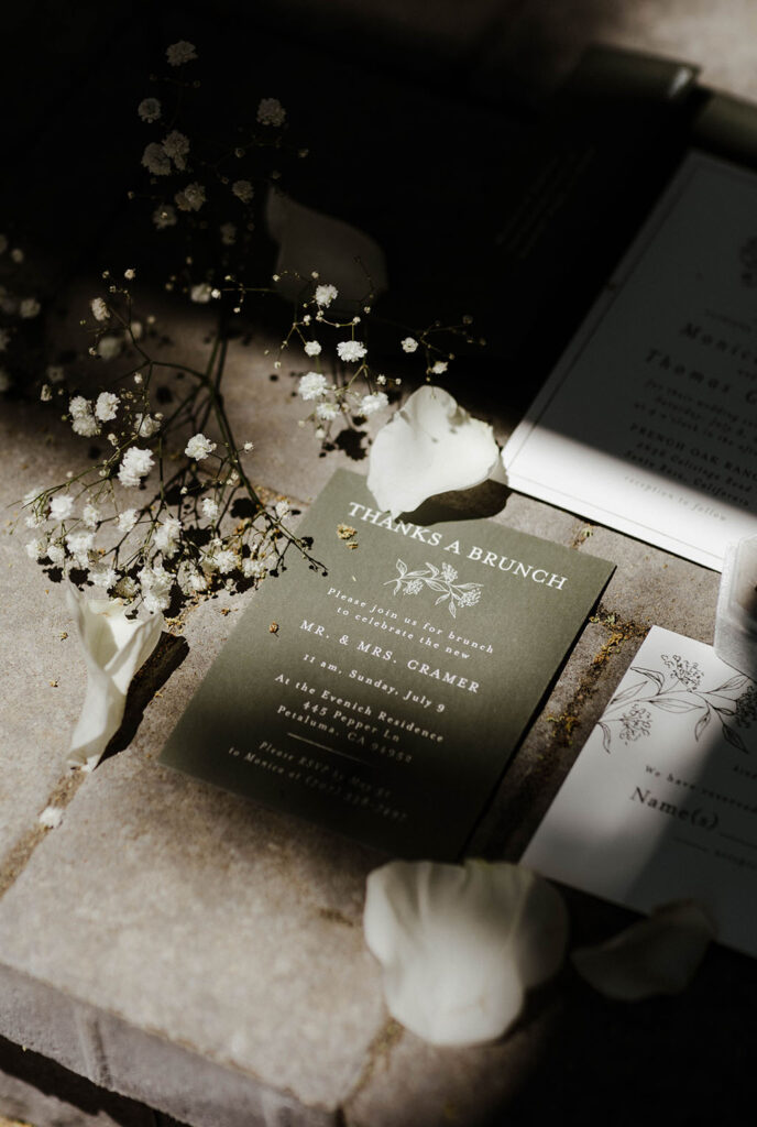 Close up of wedding invitation in flat-lay with white flowers around it at French Oak Ranch