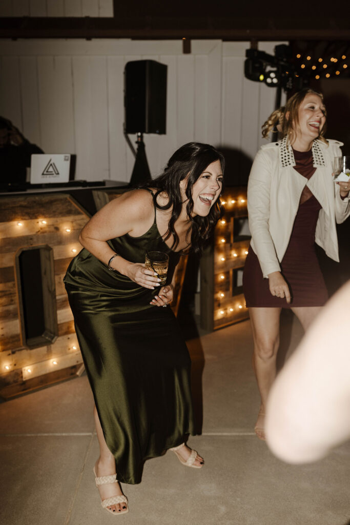 Wedding guests laughing while holding drinks during wedding reception at French Oak Ranch