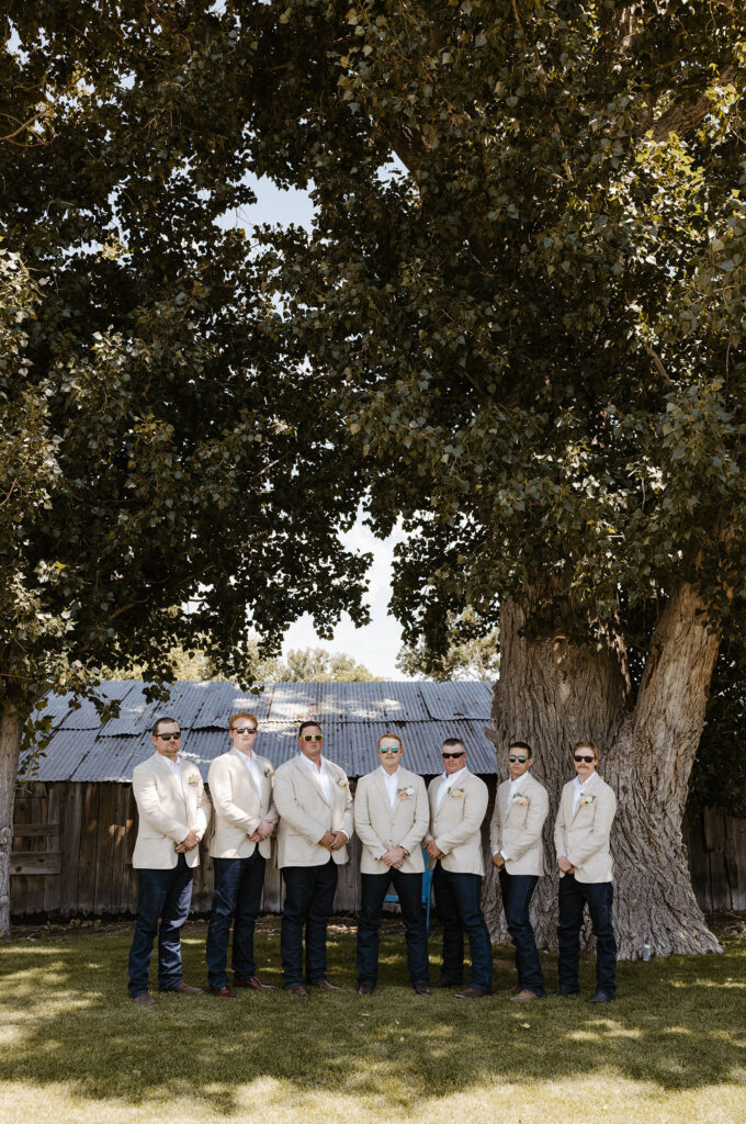 Wedding groom and groomsmen standing together and smiling at camera with hands clasped and sunglasses at Jacobs Berry Farm