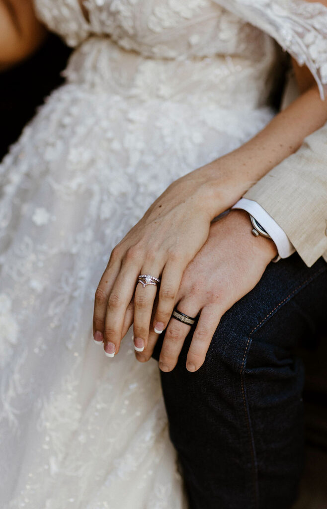 Close up of wedding couple's hands sitting on top of each other while wearing wedding rings at Jacobs Berry Farm