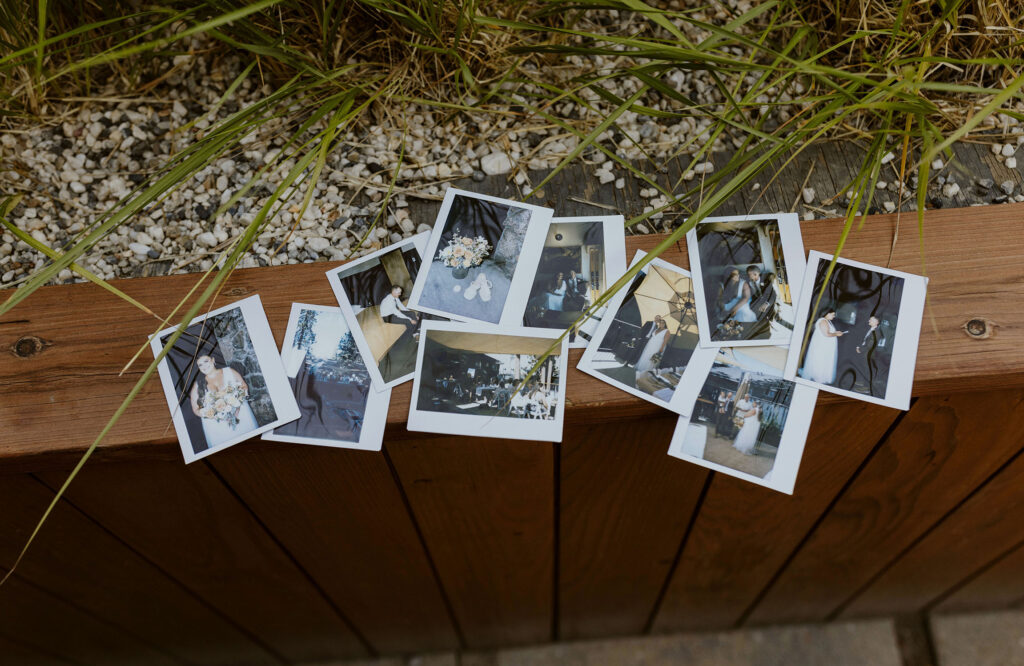 Polaroid photos of the wedding day laid out on wooden railing at the Coachman hotel in Lake Tahoe