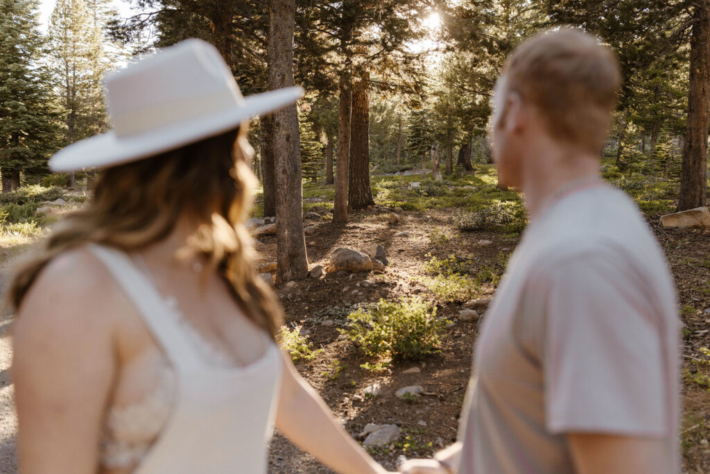 Married couple looking into distance with pine trees and shrubs at Donner Lake