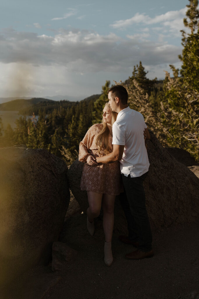 maternity couple holding each other looking at the water in lake tahoe