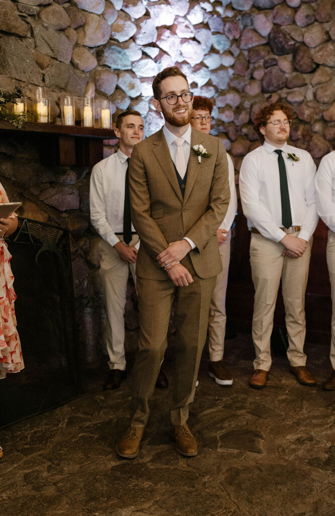 Wedding groom waiting at front of ceremony while smiling at Valhalla in Lake Tahoe