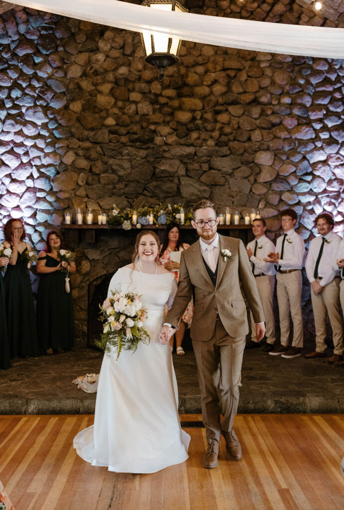 Wedding couple smiling after ceremony and holding hands about to walk down aisle at Valhalla in Lake Tahoe