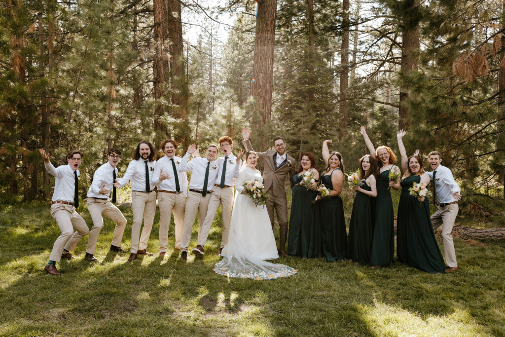 Wedding couple celebrating with groomsmen and bridesmaids with trees in background at Valhalla in Lake Tahoe
