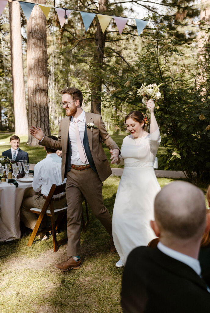 Wedding couple holding hands and celebrating during grand entrance into reception at Valhalla in Lake Tahoe