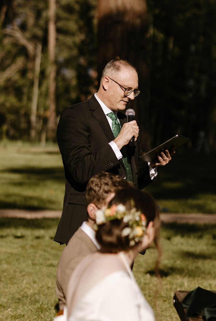 Wedding brides dad holding microphone and tablet during speeches at Valhalla in Lake Tahoe