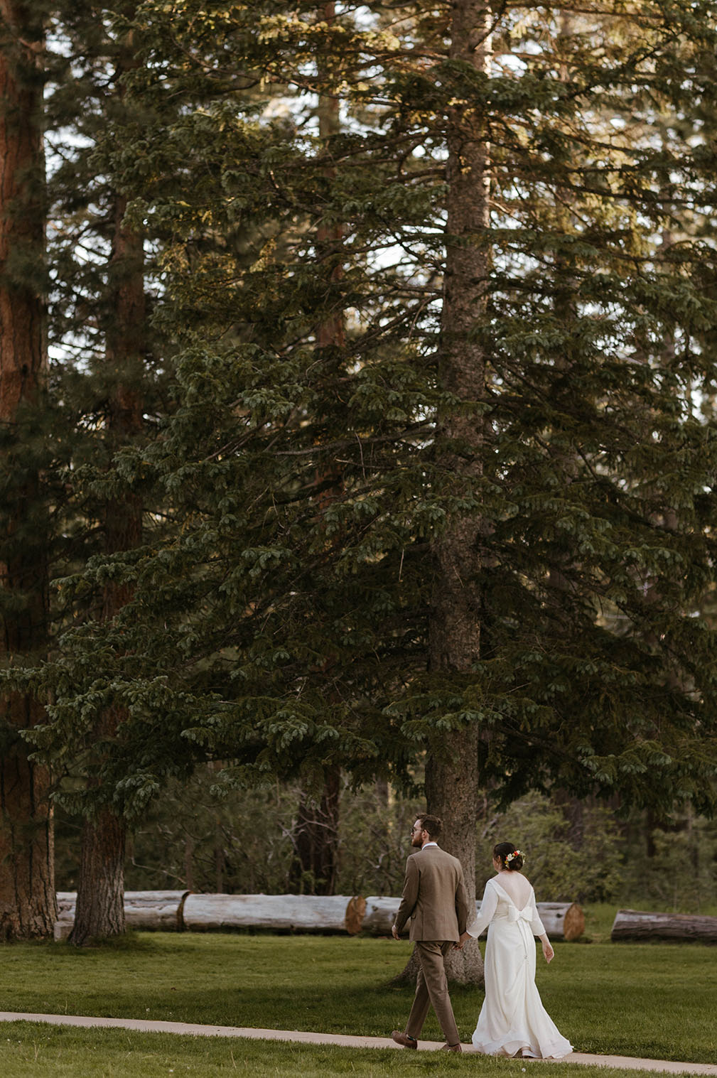 wedding couple walking under the trees at their summer wedding at valhalla lake tahoe