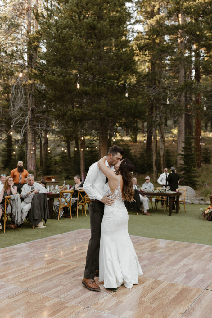 Wedding couple holding each other and kissing while on dance floor during reception at dancing pines