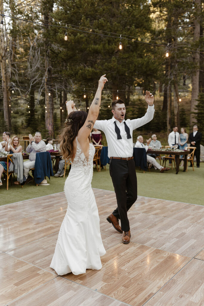 Wedding couple celebrating and dancing while on dance floor during reception at dancing pines