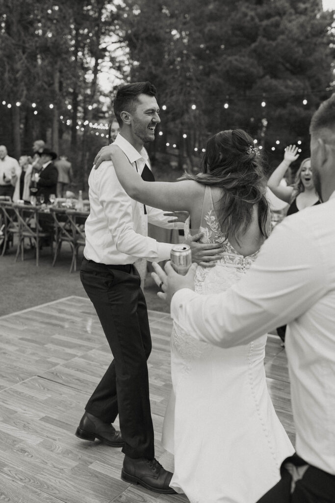 Groom holding bride while they are dancing during wedding reception at dancing pines