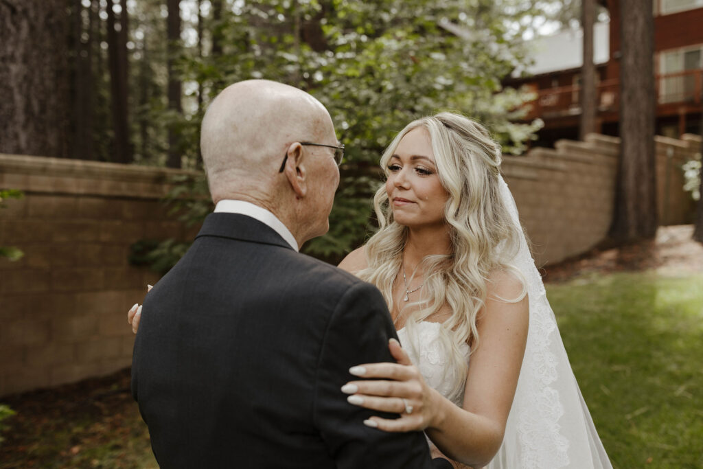 Wedding bride emotional during first look with Dad while they hold each other at Aspen Grove