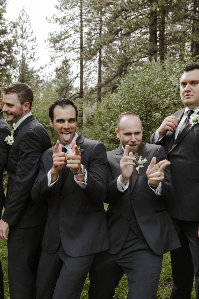 Groomsmen celebrating while standing in front of tall trees at Aspen Grove
