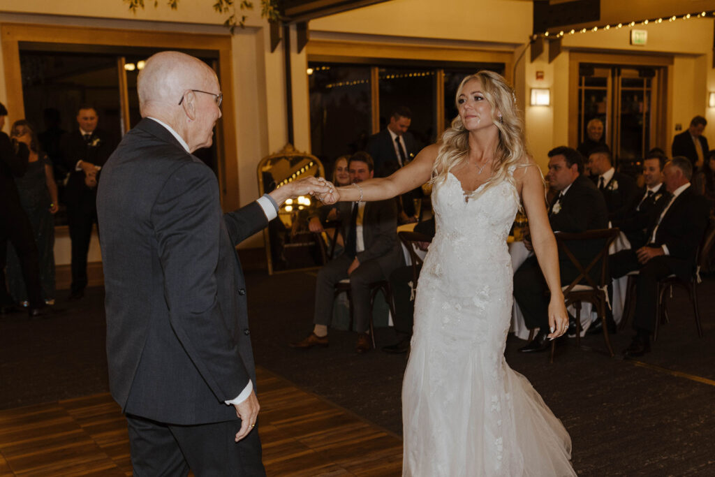 Wedding bride emotional while dancing with dad during reception inside at Aspen Grove