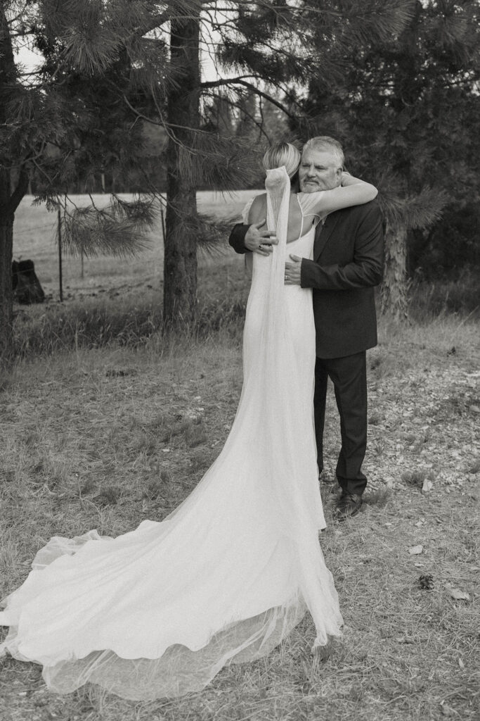 black and white photo of a bride hugging her dad at kinship ranch