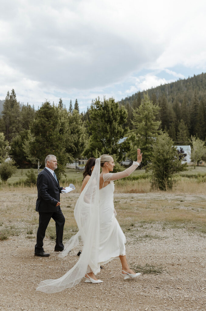 bride waving to guests with loved ones at kinship ranch