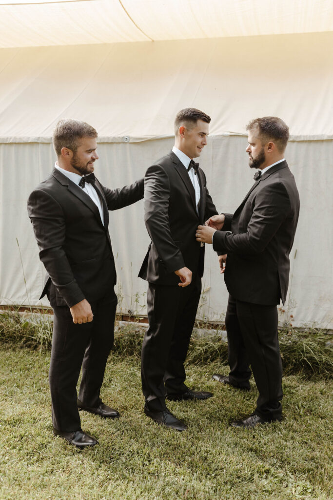 groom getting ready with 2 groomsmen at kinship ranch