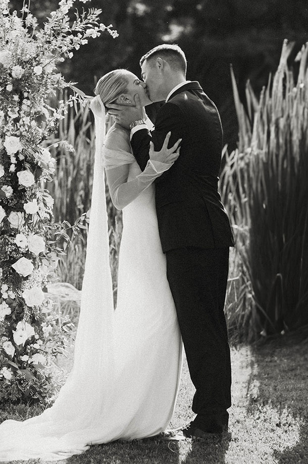bride and groom first kiss during their summer wedding at kinship ranch