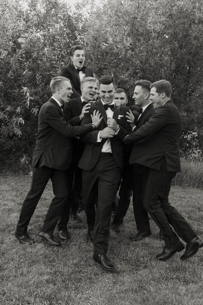 groomsmen laughing and shoving each other at kinship ranch