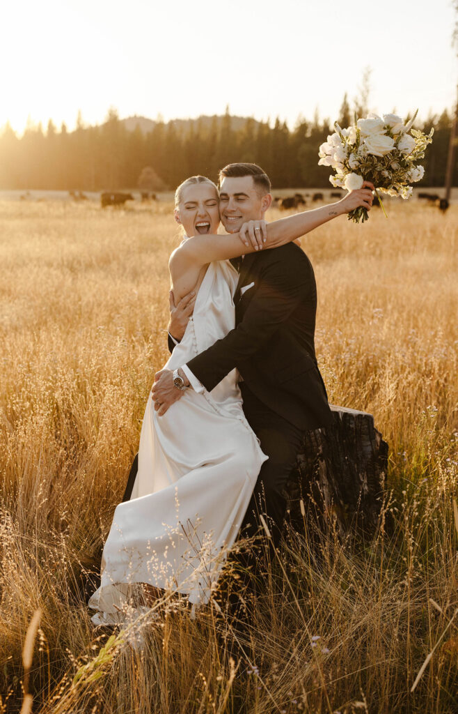 wedding couple hugging and smiling in a golden meadow at kinship ranch