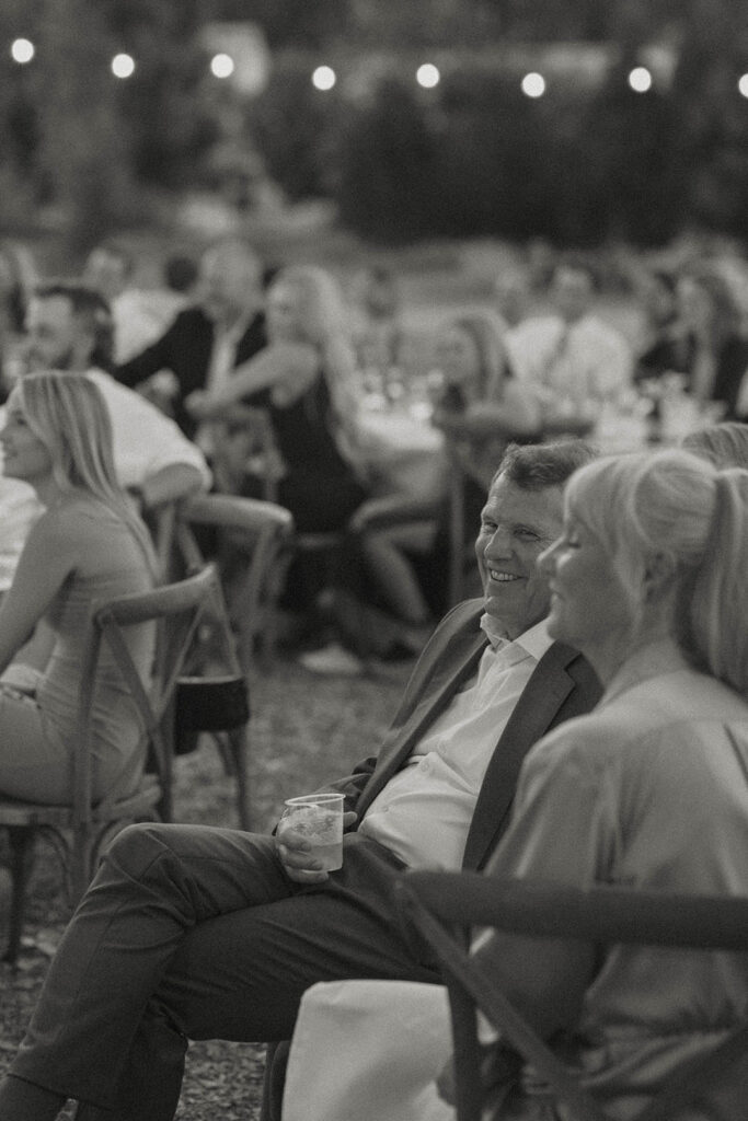 guests smiling during speeches at a summer wedding at kinship ranch