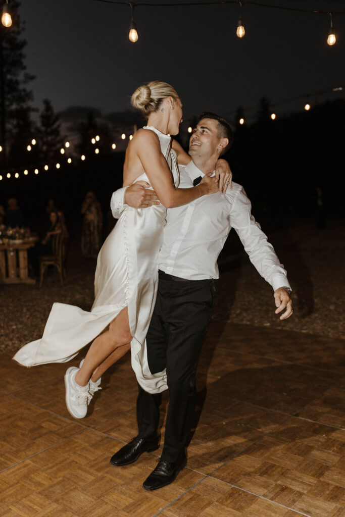 groom swinging the bride in the air at their summer wedding at kinship ranch