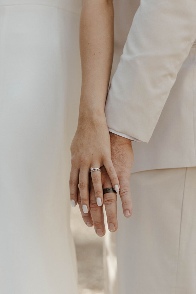 Close up of wedding couple's hands on top of each other while wearing wedding rings at the Corner Barn