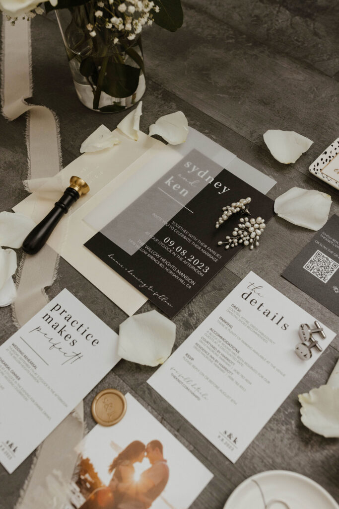 Wedding announcement and details in flat lay on dark grey wood at Willow Heights mansion