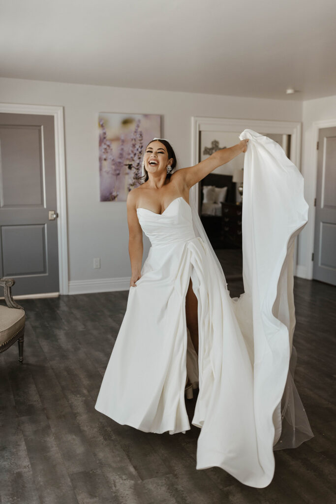 Wedding bride playing with dress tail while laughing inside at Willow Heights mansion